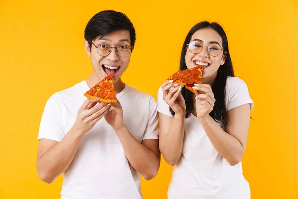 Изображение Веселой Многонациональной Пары Улыбающейся Поедающей Пиццу Желтом Фоне — стоковое фото
