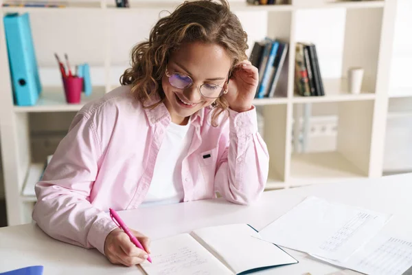 Photo Joyful Blonde Woman Wearing Eyeglasses Smiling Doing Homework While — Stock Photo, Image