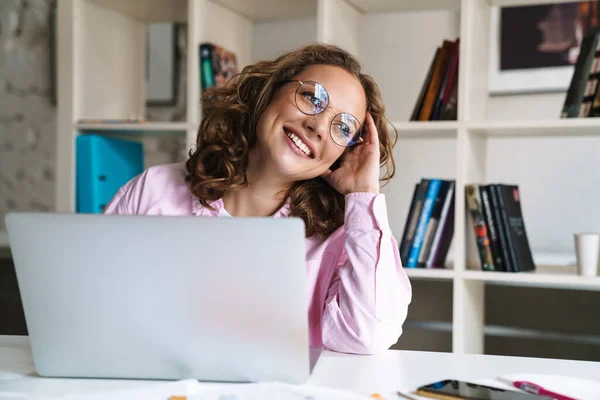 Foto Mulher Loira Alegre Usando Óculos Sorrindo Usando Laptop Enquanto — Fotografia de Stock