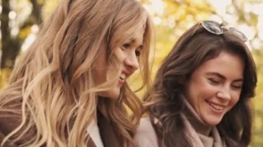 Yeşil doğa parkında gezen neşeli genç kızlar.