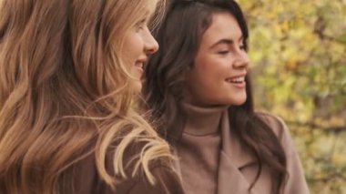 Genç mutlu kızlar arkadaşlar yeşil doğa parkında yürüyorlar