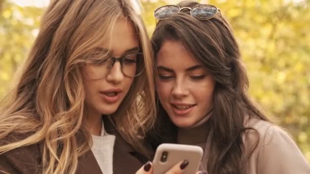 年轻而集中的女性朋友们在绿色自然公园里用手机散步 — 图库视频影像