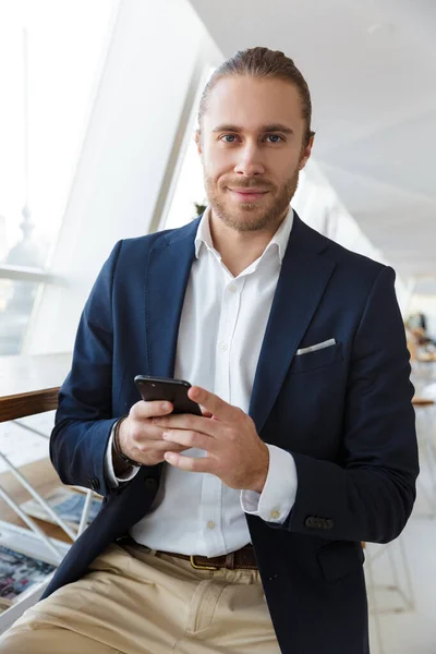 Image Pleased Handsome Young Businessman Indoors Office Using Mobile Phone — Stock Photo, Image