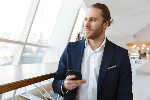 Photo Concentrated Handsome Young Businessman Indoors Office Using Mobile Phone — Stock Photo, Image