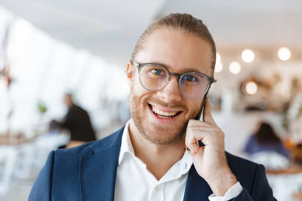 Imagen Joven Empresario Optimista Guapo Satisfecho Interior Oficina Hablando Por — Foto de Stock