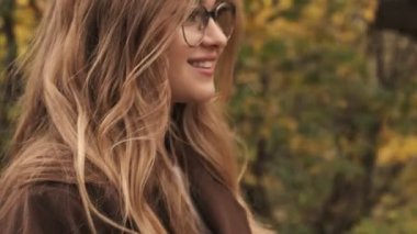 Yeşil doğa parkında gezen iyimser mutlu genç kız.