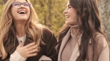 Yeşil doğa parkında gezen mutlu genç kızlar.