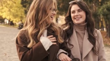 Genç mutlu, iyimser kızlar arkadaşlar yeşil doğa parkında yürüyorlar.