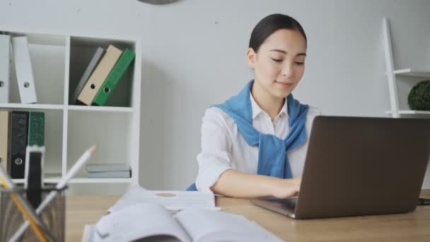 Uma Jovem Secretária Asiática Muito Sorridente Sentada Mesa Digitando Seu — Vídeo de Stock