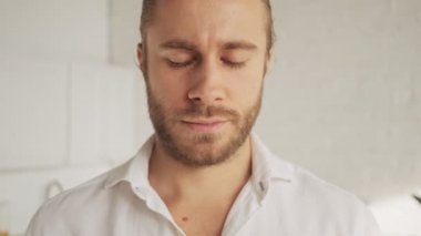 Sakin ve yakışıklı bir genç adam evdeki oturma odasında gözlerini açıyor.