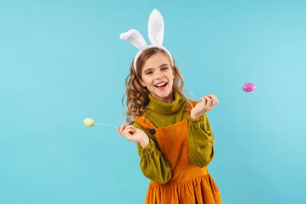 图片中 一个可爱的快乐的小女孩在东方假日兔子耳朵隔离在蓝色的墙背景下 — 图库照片