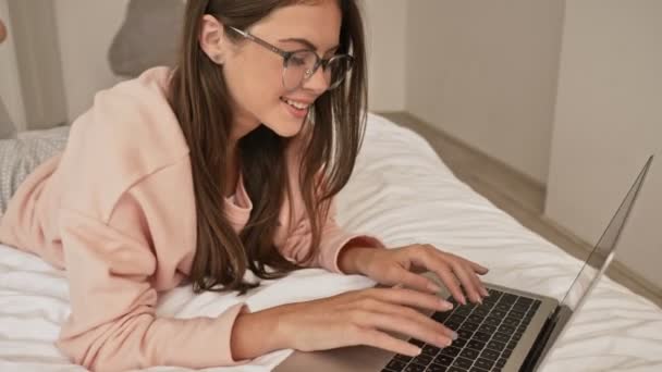 Beautiful Young Girl Wearing Glasses Typing Her Laptop Computer Laying — Stock Video