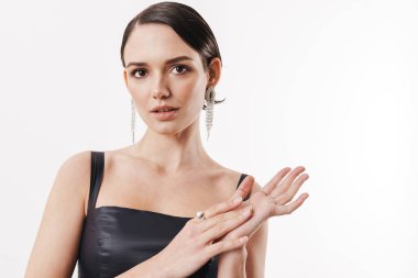 Elbise giymiş güzel esmer bir kadının beyaz arka planda izole edilmiş kameraya bakışı.