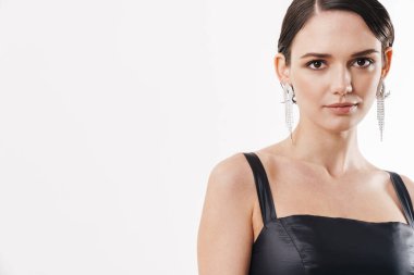 Elbise giymiş güzel esmer bir kadının beyaz arka planda izole edilmiş kameraya bakışı.