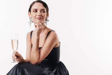 Beyaz arka planda izole edilmiş, gülümseyen ve elinde şampanya kadehi tutan büyüleyici, genç bir kadının görüntüsü.