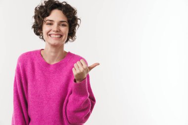 Gülümseyen ve işaret eden güzel bir kadın görüntüsü beyaz arka planda izole edilmiş.