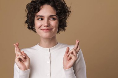 Gülümseyen güzel bir kadının el ele tutuşması bej arka planda izole edilmiş iyi şanslar.