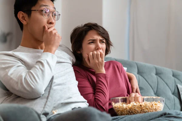 Zdjęcie Zszokowanej Wielonarodowej Pary Jedzącej Popcorn Oglądającej Film Siedząc Kanapie — Zdjęcie stockowe