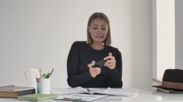 Duygusal Genç Bir Sarışın Kadın Beyaz Bir Ofisteki Masada Oturan — Stok video