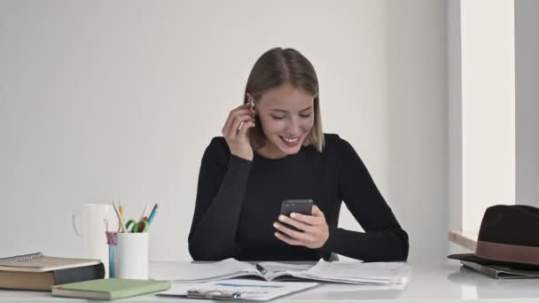 Una Joven Rubia Feliz Está Poniendo Los Auriculares Sentados Mesa — Vídeo de stock