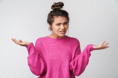 Pembe kazaklı hoş bir kadının beyaz arka planda elleri havada poz verirken görüntüsü.