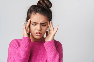 Baş ağrısı olan, şakaklarını ovalayan, beyaz arka planda izole edilmiş, mutsuz bir kadın görüntüsü.