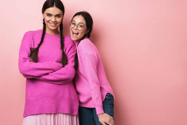 二つの幸せな十代の女の子のイメージで毛のあるカジュアル服で笑顔でカメラ孤立上のピンクの背景 — ストック写真