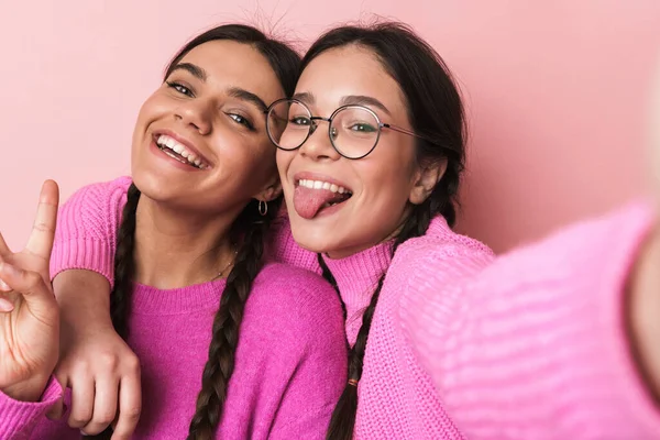 二つの幸せな十代の女の子のイメージで毛のあるカジュアル服で笑顔でカメラ孤立上のピンクの背景 — ストック写真