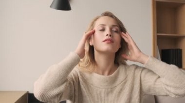 Genç konsantre olmuş sarışın kadın sabahları evde meditasyon yapıyor.