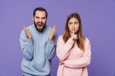 Kız arkadaşının yanında çığlık atan bir adamın resmi. Mor arka planda izole edilmiş sessizlik hareketi..