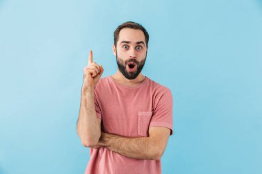 Şok olmuş genç bir adamın görüntüsü mavi duvar arka planında izole edilmiş bir şekilde duruyor..