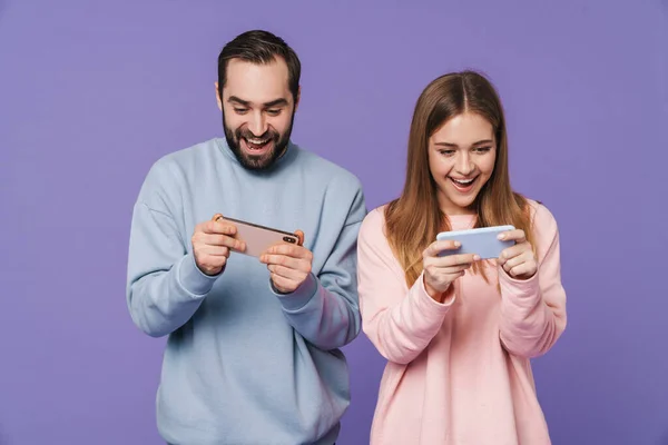興奮した感情的な愛のカップルのイメージは 携帯電話によって紫色の背景ゲームを分離 — ストック写真