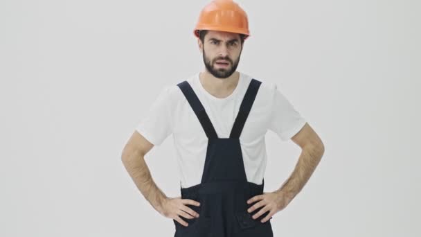 Joven Constructor Barbudo Descontento Aislado Sobre Fondo Pared Blanco Casco — Vídeo de stock