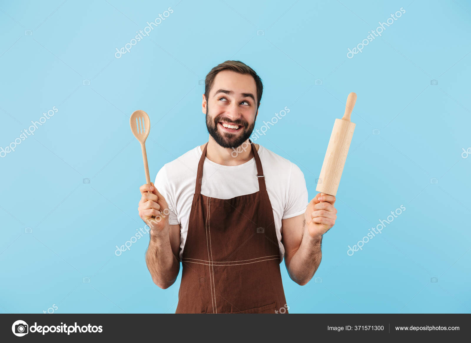 Cheerful young man baker standing at bakery holding bread Stock Photo by  vadymvdrobot