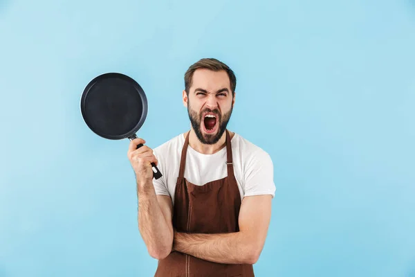 Foto Mladého Křičí Nespokojen Muž Kuchař Izolované Přes Modré Stěny — Stock fotografie