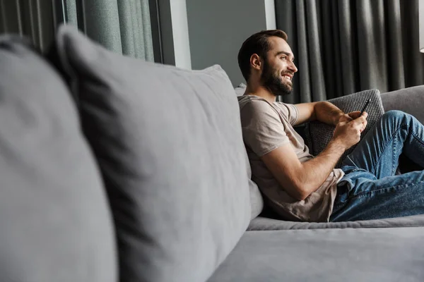 Imagen Joven Feliz Contento Interior Casa Sofá Usando Teléfono Móvil — Foto de Stock