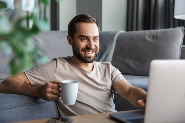 Attraktiver Glücklicher Junger Mann Der Auf Einem Fußboden Wohnzimmer Sitzt — Stockfoto