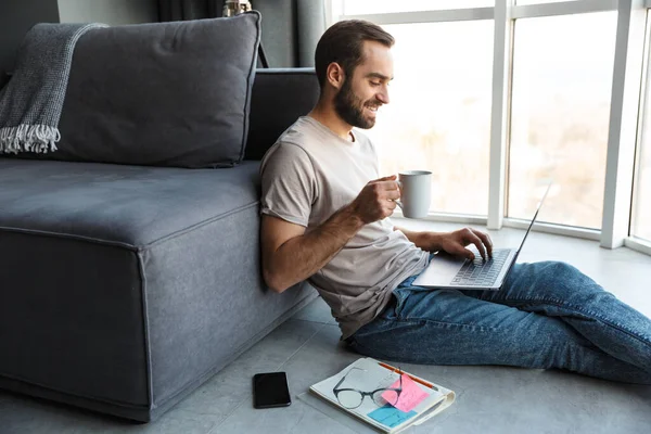 Atractivo Joven Inteligente Feliz Sentado Piso Sala Estar Trabajando Ordenador — Foto de Stock