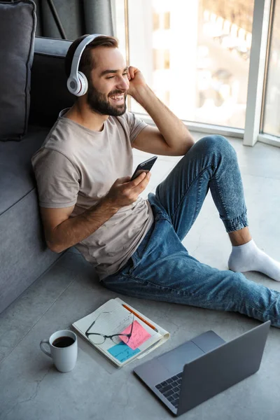 Atractivo Joven Inteligente Sentado Piso Sala Estar Escuchando Música Con — Foto de Stock