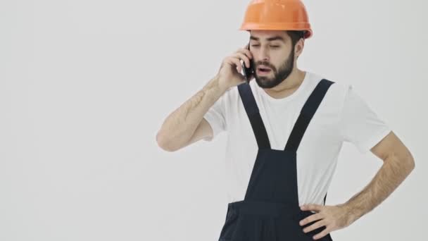 가난젊은 턱수염 건축가가 헬멧을 핸드폰으로 말하는 가운데흰 고립되었다 — 비디오