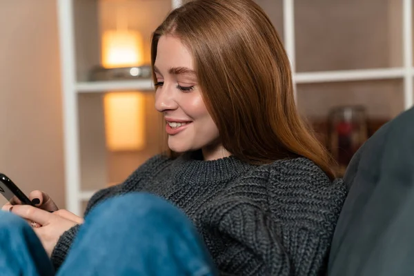 携帯電話を使って家の中で幸せな楽観的な陽気な若い女性のイメージ — ストック写真