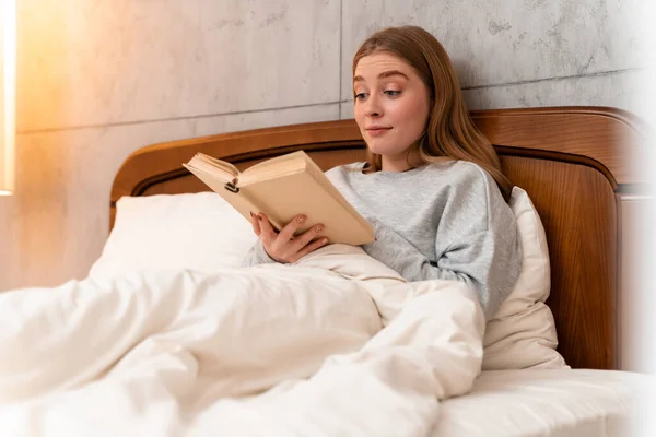 Foto Una Mujer Joven Bonita Sorprendida Casa Libro Lectura Cama —  Fotos de Stock