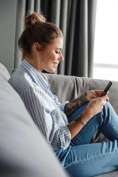 Imagem Jovem Mulher Feliz Camisa Listrada Sorrindo Usando Celular Enquanto — Fotografia de Stock