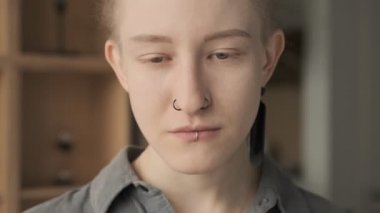 Evde kameraya bakan rastalı ciddi bir kız.