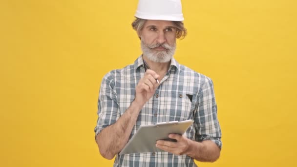 Senior Guapo Hombre Serio Concentrado Constructor Casco Aislado Sobre Fondo — Vídeos de Stock