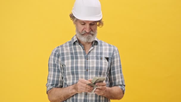 Senior Positivo Otimista Homem Construtor Capacete Isolado Sobre Fundo Amarelo — Vídeo de Stock
