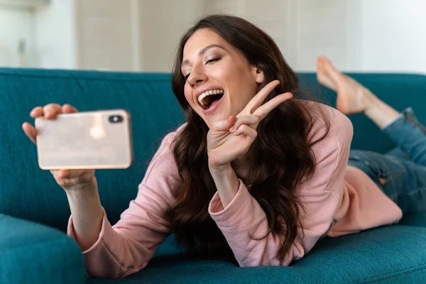 Bild Positiv Glad Ung Kvinna Inomhus Selfie Med Mobiltelefon Soffan — Stockfoto