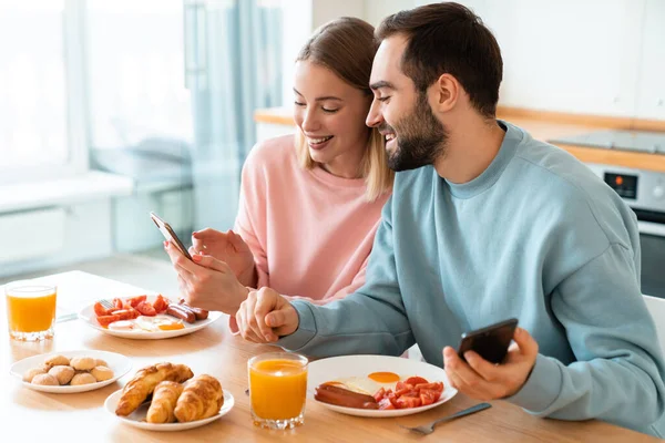 Retrato Una Joven Pareja Alegre Usando Teléfonos Celulares Sonriendo Mientras — Foto de Stock