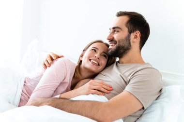 Güzel mutlu bir çiftin portresi. Günlük kıyafetler giyiyorlar. Gülümsüyorlar ve sarılıyorlar.