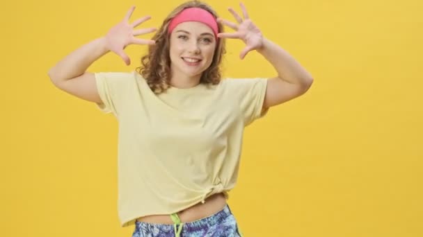 Улыбающаяся Счастливая Молодая Спортсменка Спортивной Одежде Танцует Изолированно Жёлтом Фоне — стоковое видео